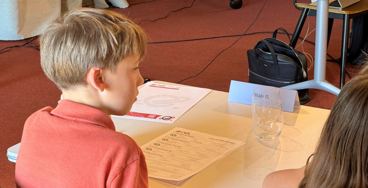 Un enfant est assis et &eacute;coute Nicolas Pourbaix