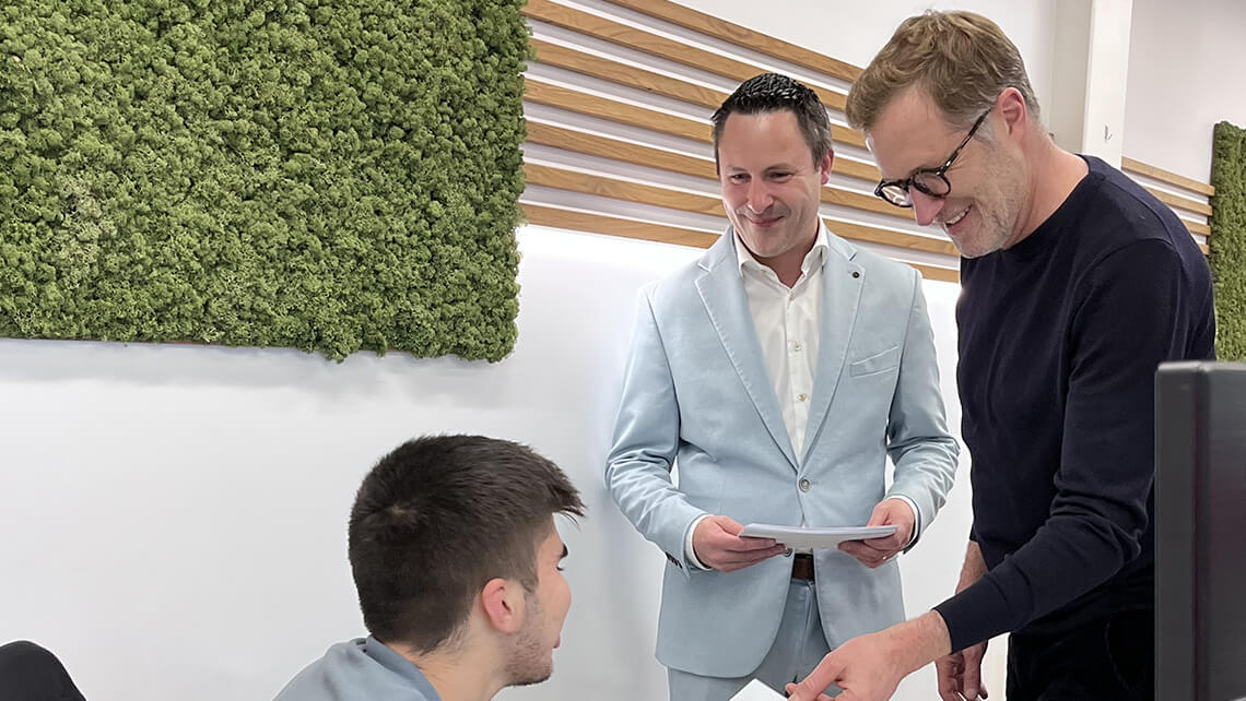 Paul Magnette et Nicolas Pourbaix, souriants, échangent quelques mots avec notre stagiaire qui s'occupe de l'accueil des clients e-net. group.