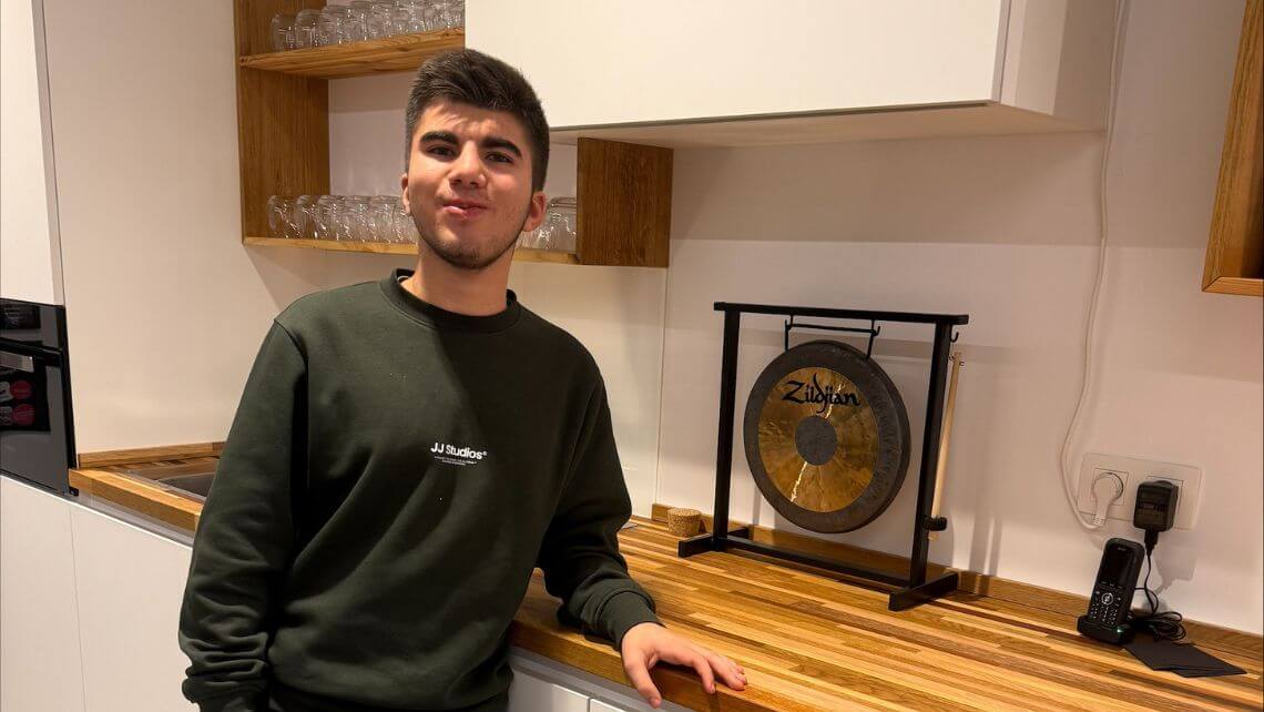 Lilian dans la cuisine e-net, le coude posé sur le plan de travail